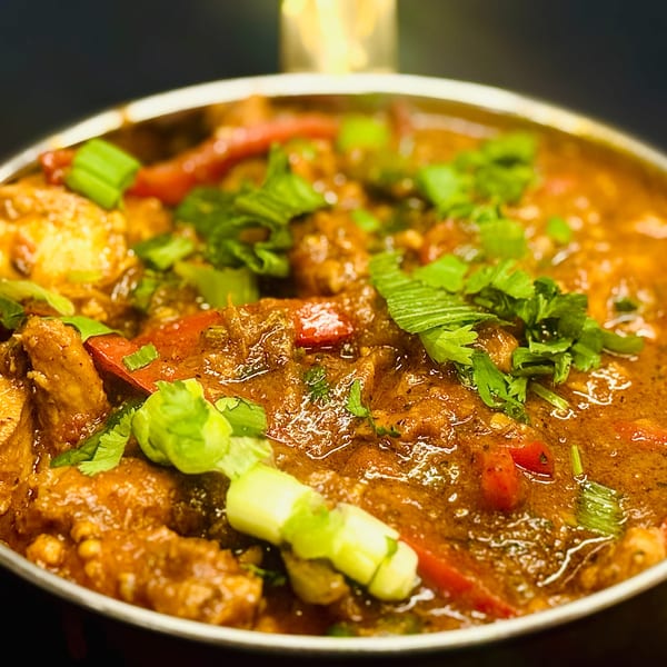 Close-up of Sherpa Grill 2's Indian Nepali curry, garnished with fresh cilantro and green onions.