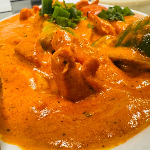 Close-up of Sherpa Grill 2's Indian Nepali chicken curry with green peppers and scallions.