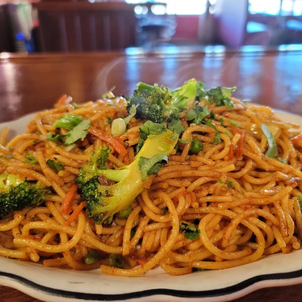 A close-up of Sherpa Grill 2's Indian Nepali noodles with broccoli, carrots, and cilantro.